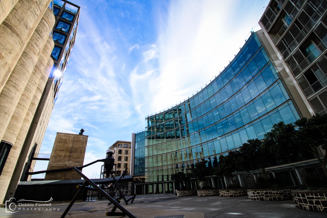 Plaza beside Radisson RED, framed by concrete silos and curved glass façades