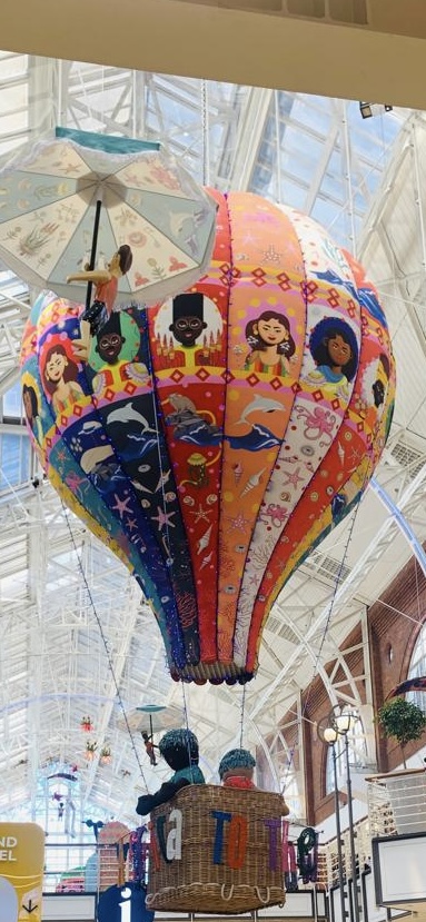 Victoria Wharf interior with a colourful suspended balloon display beneath the glazed roof and white structural framework